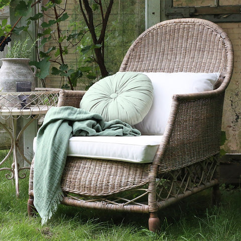 Handwoven rattan armchair with cushions for garden or conservatory
