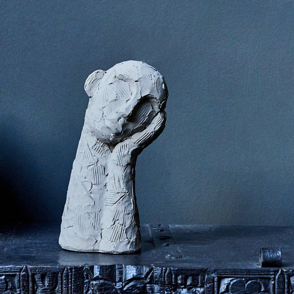 abstract sculpture man with head in hand grey cement rustic