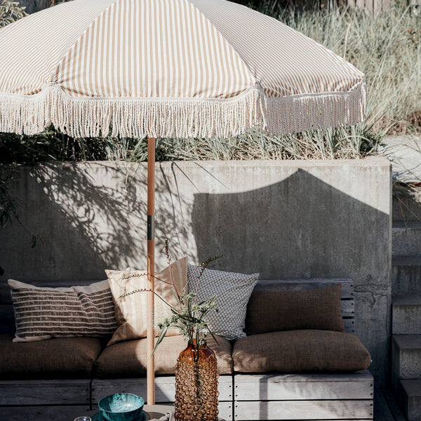 Vintage style sturdy wooden garden parasol sand stripe on white background cotton fringes